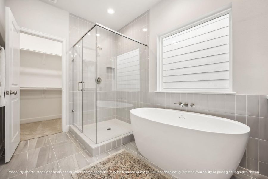 Spa-Like Retreat. The luxurious primary bath features a freestanding tub, a walk-in shower, and designer tile for a relaxing escape.
