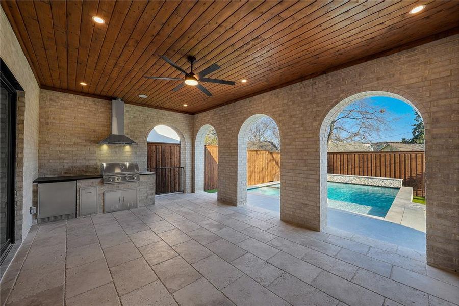 Fenced backyard featuring area for grilling, a patio area, ceiling fan, and an outdoor pool Fenced backyard featuring area for grilling, a patio area, ceiling fan, and an outdoor pool