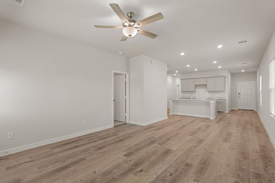 A room with a wood floor and a ceiling fan.