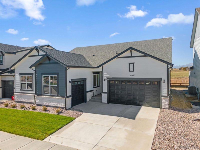Front exterior of a new home in Highlands Preserve, Mead, CO, highlighting curb appeal (Image 1).