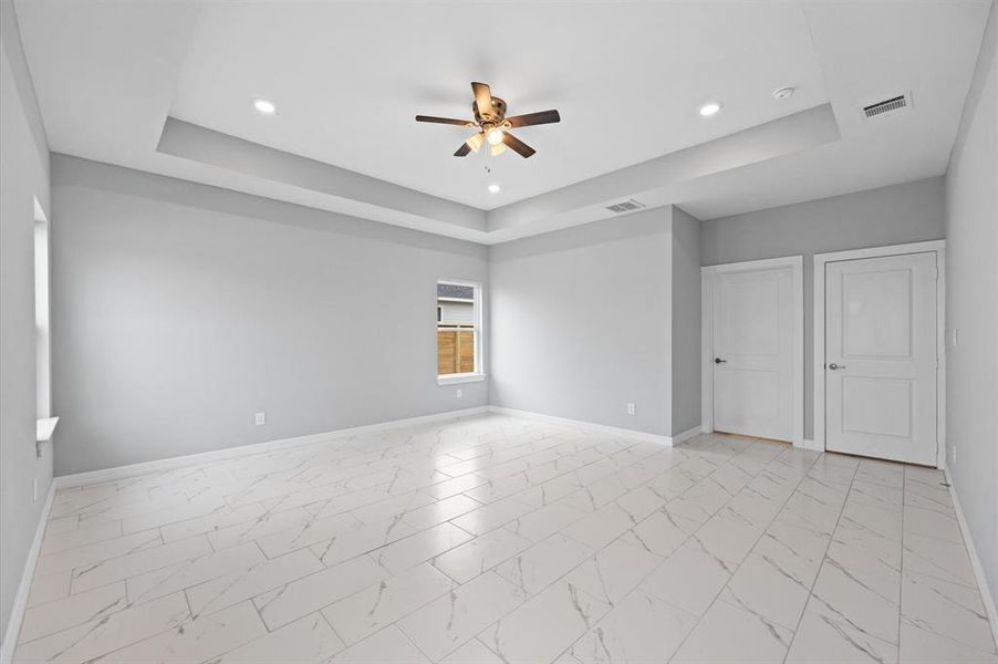 Oversized primary bedroom with high ceilings and plenty of natural light. No carpet!