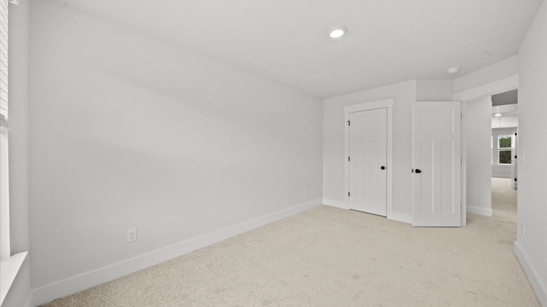 First-class secondary bedroom with comfortable carpeted flooring and generous closet space