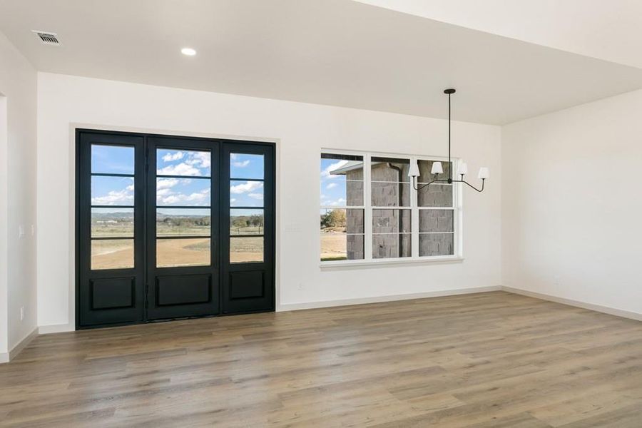 Foyer entrance featuring a chandelier and light wood-style flooring Foyer entrance featuring a chandelier and light wood-style flooring