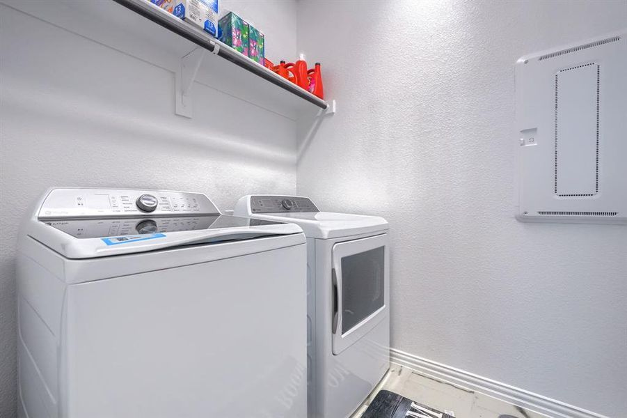 Washroom with a textured wall and washer and clothes dryer Washroom with a textured wall and washer and clothes dryer