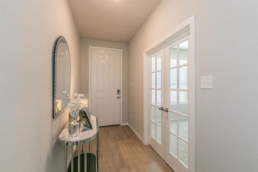 Doorway to outside with wood finished floors and baseboards