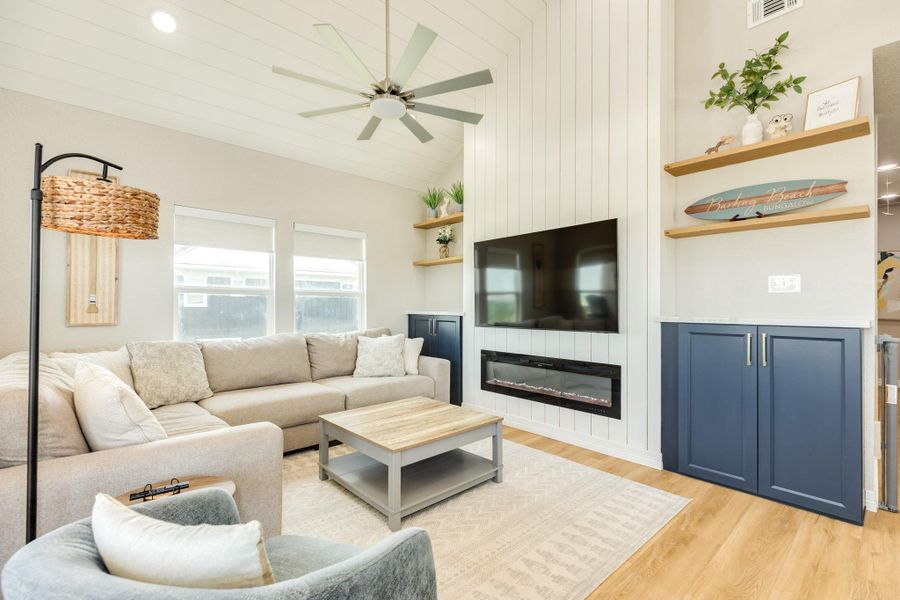 Stylish feature wall with a modern electric fireplace, built-in cabinetry, and floating shelves creates a warm focal point in this comfortable gathering space.