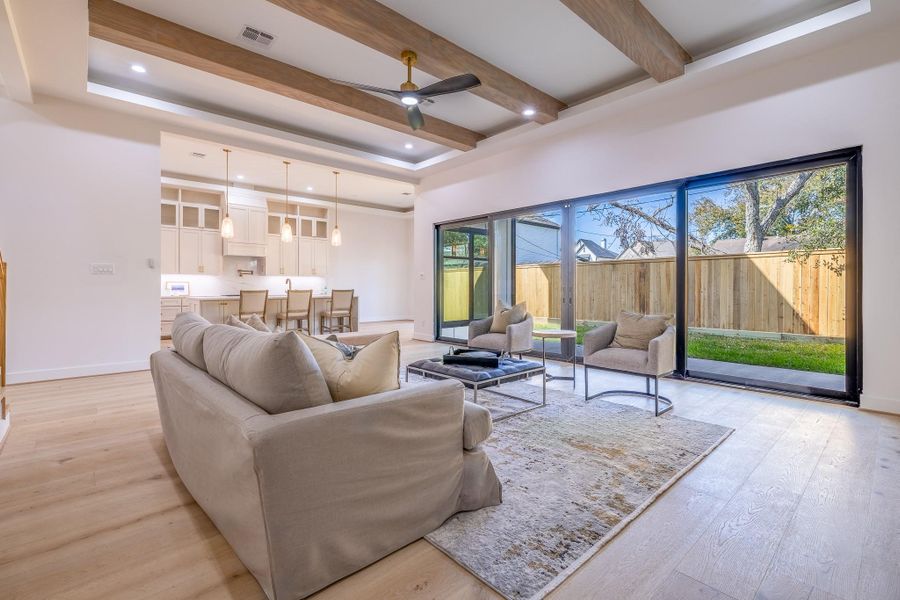 Open living space with full-height sliders overlooking the backyard, creating a true indoor-outdoor lifestyle experience.