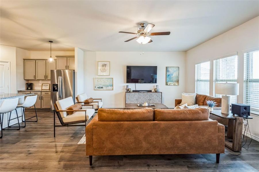 Living area featuring ceiling fan and dark wood-type flooring