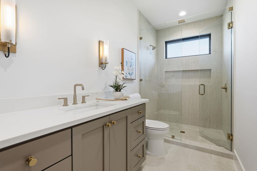 Full bath featuring vanity, a stall shower, and light tile patterned flooring Full bath featuring vanity, a stall shower, and light tile patterned flooring