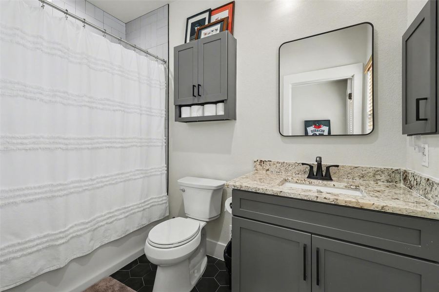 Full Bathroom upstairs with vanity, shower / bath combination with curtain, and dark tile patterned flooring