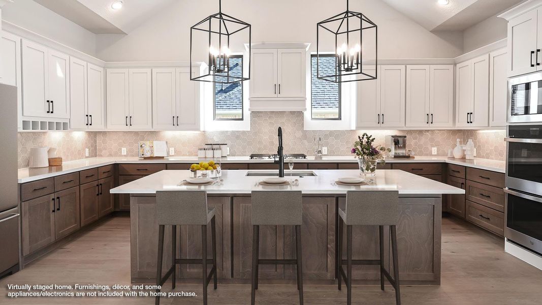 Kitchen with an island with sink, tasteful backsplash, white cabinets, decorative light fixtures, and vaulted ceiling