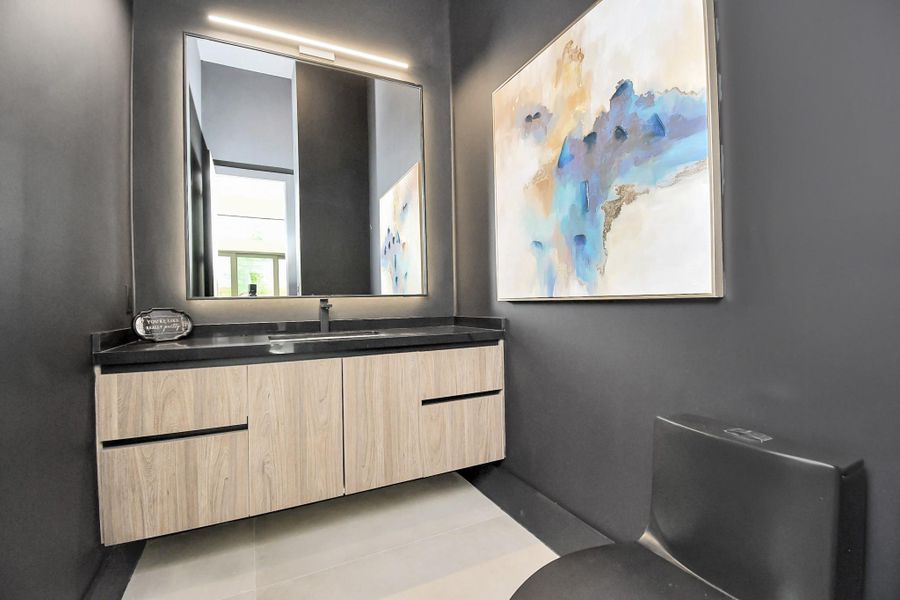 Half bathroom with floating shelves and black chic toilette. Half bathroom with floating shelves and black chic toilette.