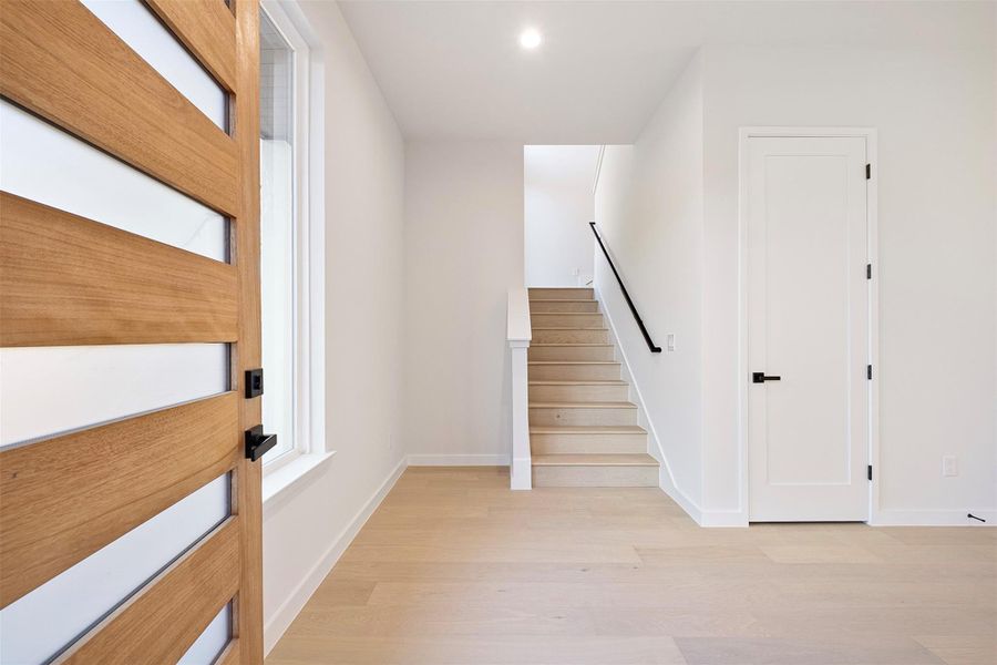Staircase featuring wood finished floors and recessed lighting