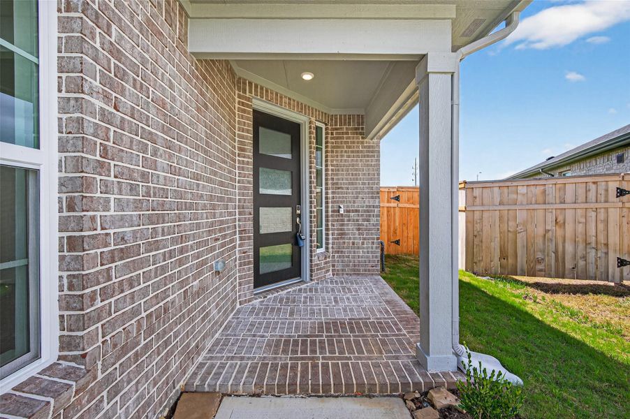 The modern side entry, featuring a sleek door design with frosted glass panels that bring in natural light while maintaining privacy.