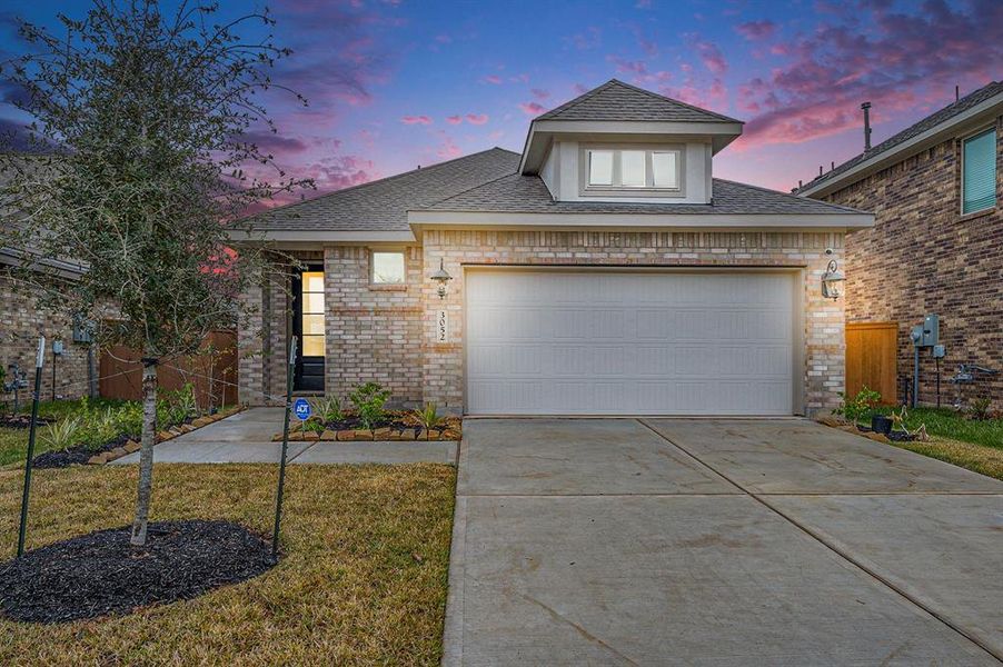 This charming brick home features a modern design with a two-car garage and well-maintained landscaping.