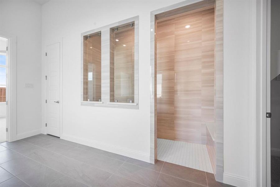 View of huge walk in shower with tile patterned flooring