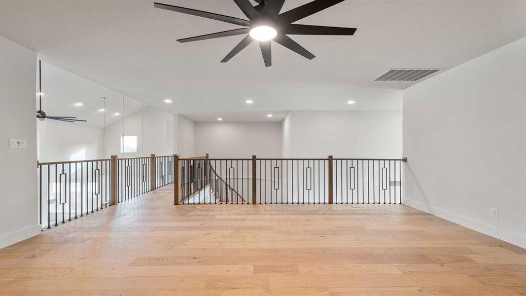 Empty room with ceiling fan and light hardwood / wood-style flooring