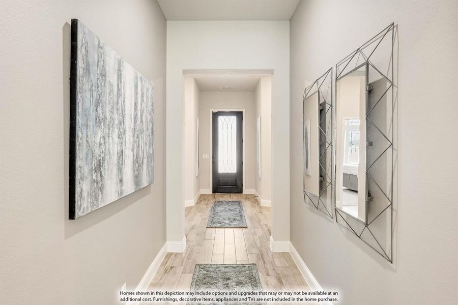 Entryway hallway with light wood floors, dark front door with glass panel, and decorative wall art and mirror. Entryway hallway with light wood floors, dark front door with glass panel, and decorative wall art and mirror.