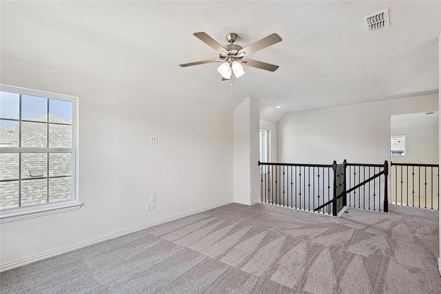 Unfurnished room with carpet, ceiling fan, and lofted ceiling