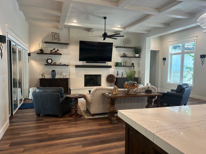 Living area with beam ceiling, a gas starter log fireplace, coffered ceiling, and ceiling fan Living area with beam ceiling, a gas starter log fireplace, coffered ceiling, and ceiling fan