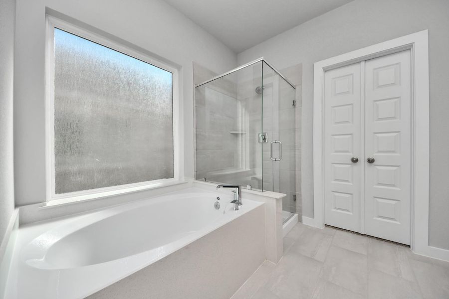 Indulge in a spa-like retreat within the confines of this primary bathroom. Delight in a spacious walk-in shower enveloped in stylish tile surround, unwind in a separate garden tub adorned with custom detailing. Sample photo of completed home with similar floor plan. Actual colors and selections may vary. Indulge in a spa-like retreat within the confines of this primary bathroom. Delight in a spacious walk-in shower enveloped in stylish tile surround, unwind in a separate garden tub adorned with custom detailing. Sample photo of completed home with similar floor plan. Actual colors and selections may vary.