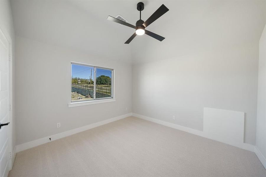 Unfurnished room featuring light carpet, ceiling fan, and lofted ceiling Unfurnished room featuring light carpet, ceiling fan, and lofted ceiling