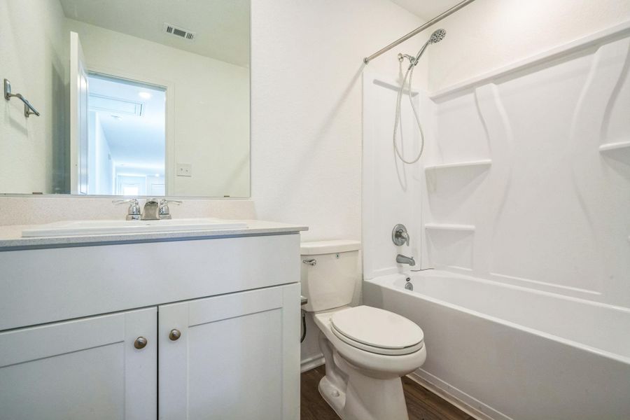 A well-appointed bath features a sleek vanity and a pristine shower-over-tub combination. A well-appointed bath features a sleek vanity and a pristine shower-over-tub combination.