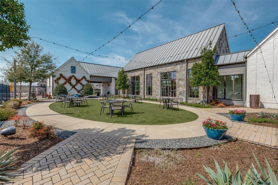 Back of house featuring a standing seam roof, a patio area, and stone siding
