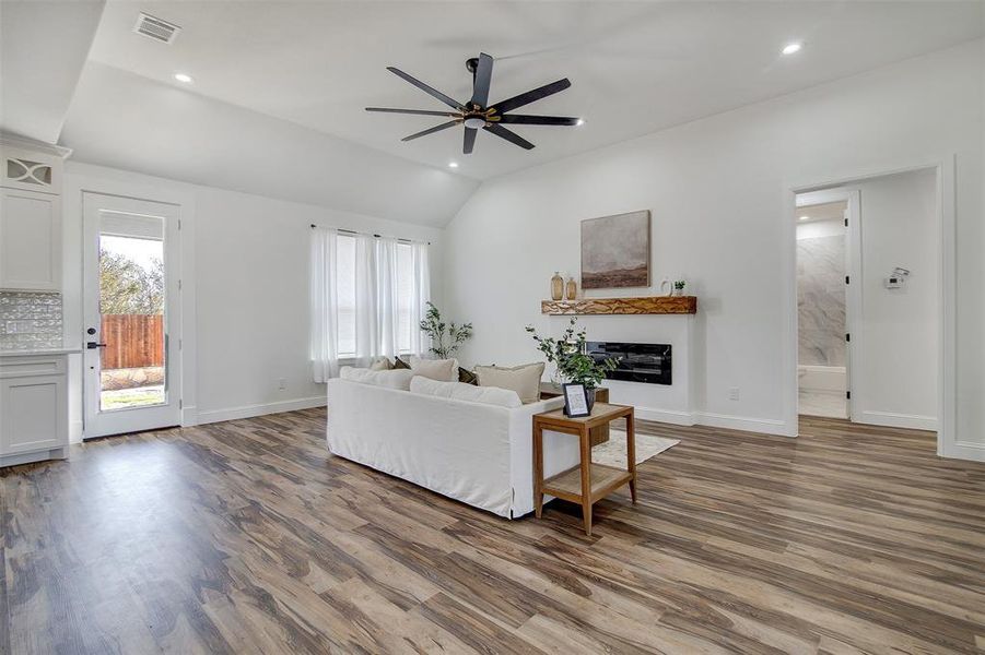 Living room featuring hardwood / wood-style floors, plenty of natural light, and vaulted ceiling