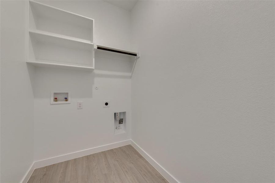 Laundry room featuring hardwood / wood-style flooring, hookup for a gas dryer, washer hookup, and electric dryer hookup