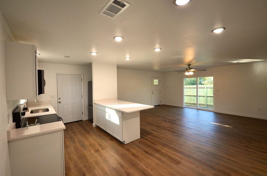Kitchen with white cabinetry, range with electric cooktop, a peninsula, dark wood finished floors, and open floor plan