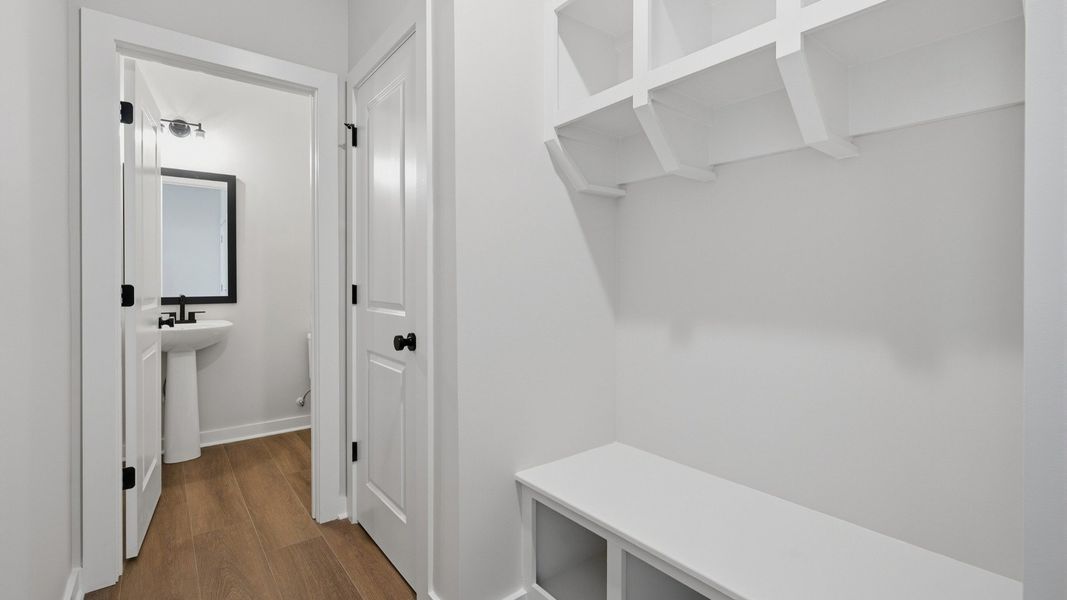 Hallway with white drop-zone and powder room