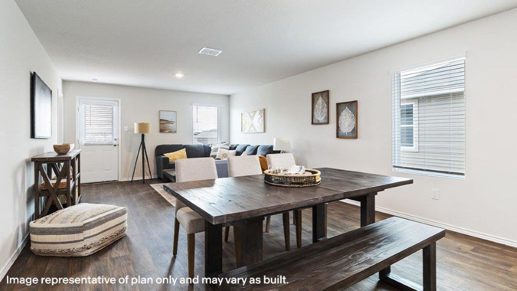 An open-concept living and dining area features rich wood flooring and abundant natural light. An open-concept living and dining area features rich wood flooring and abundant natural light.