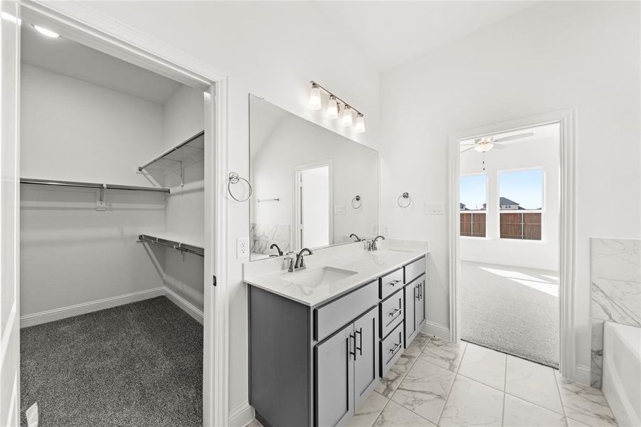 Primary suite offers dual vanity with walk-in closet
