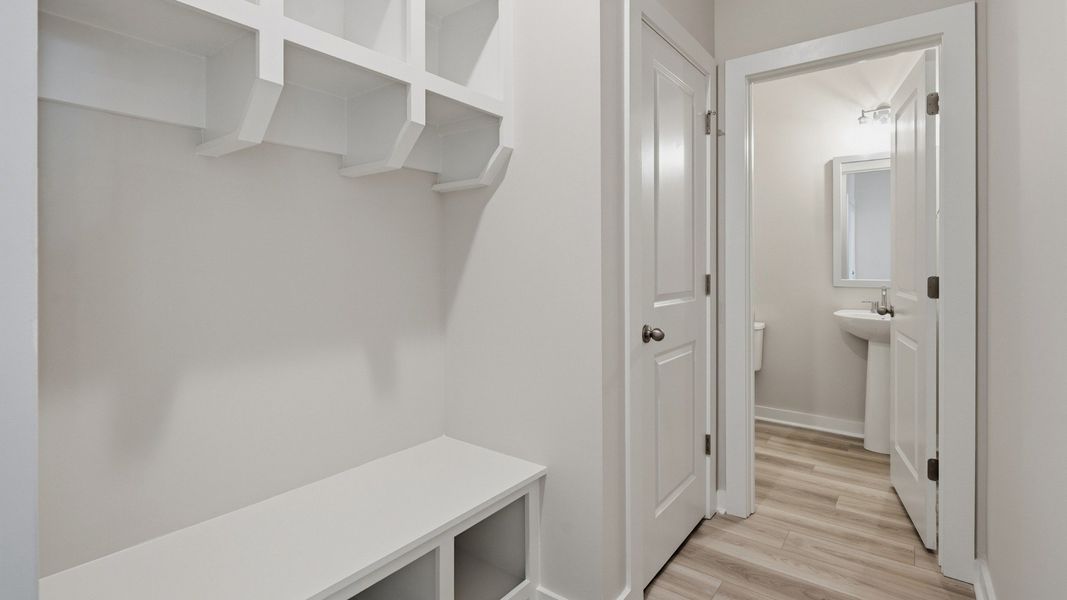 Hallway with white drop-zone and powder room