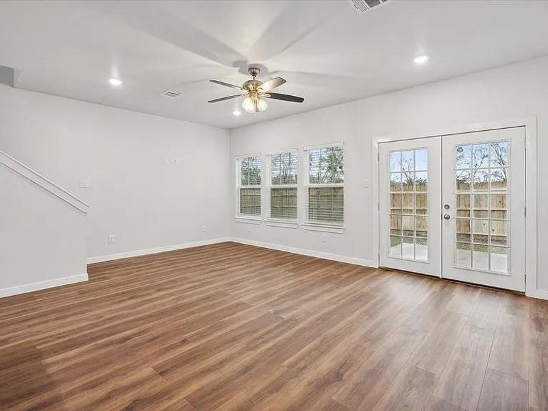 Unfurnished room featuring french doors, ceiling fan, a wealth of natural light, and hardwood / wood-style flooring