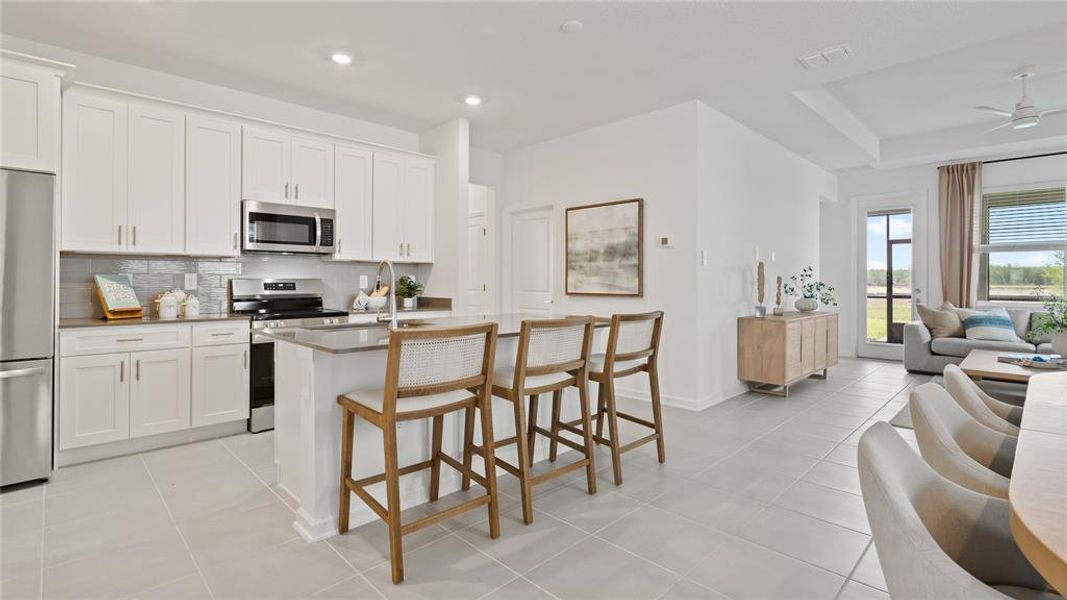 Kitchen featuring stainless steel appliances, tasteful backsplash, open floor plan, light tile patterned flooring, and recessed lighting Kitchen featuring stainless steel appliances, tasteful backsplash, open floor plan, light tile patterned flooring, and recessed lighting