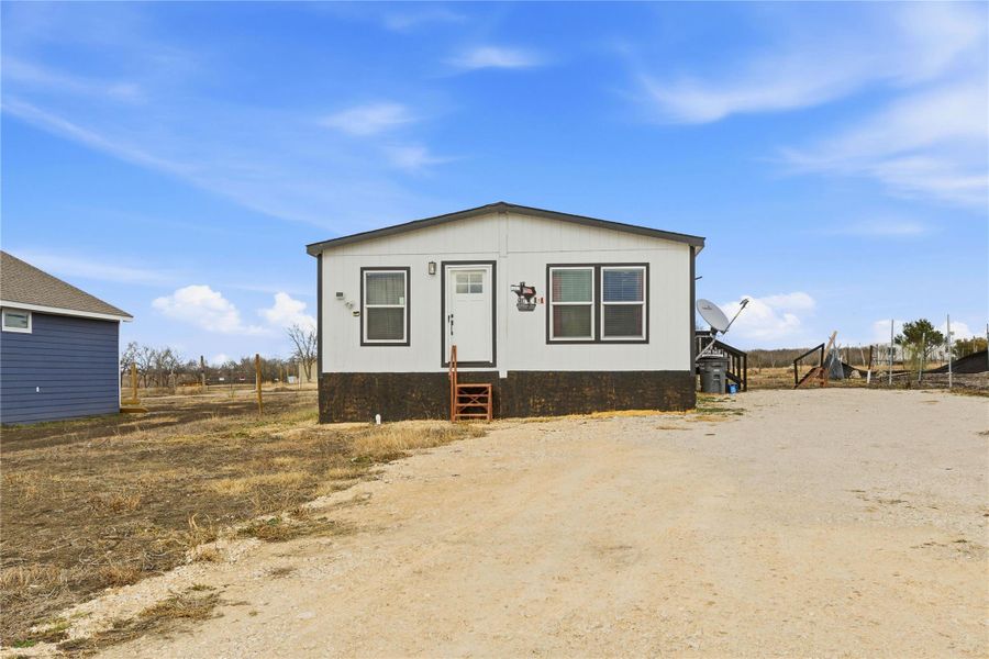 A compact residence with modern exterior finishes offers a private setting on a clear day.