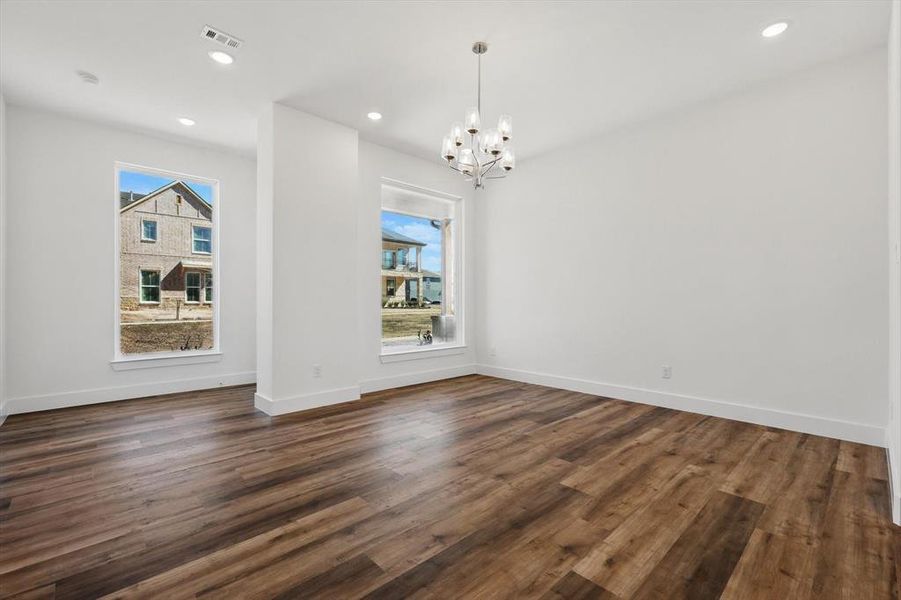 Unfurnished dining area featuring dark wood-style floors, recessed lighting, visible vents, and baseboards