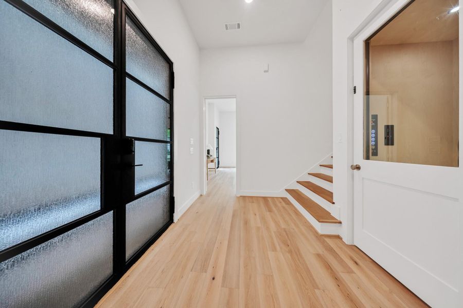 Enter through the front doors into the first floor, featuring a bedroom or office, a powder bath, and access to the stairs or elevator to the upper levels. Enter through the front doors into the first floor, featuring a bedroom or office, a powder bath, and access to the stairs or elevator to the upper levels.
