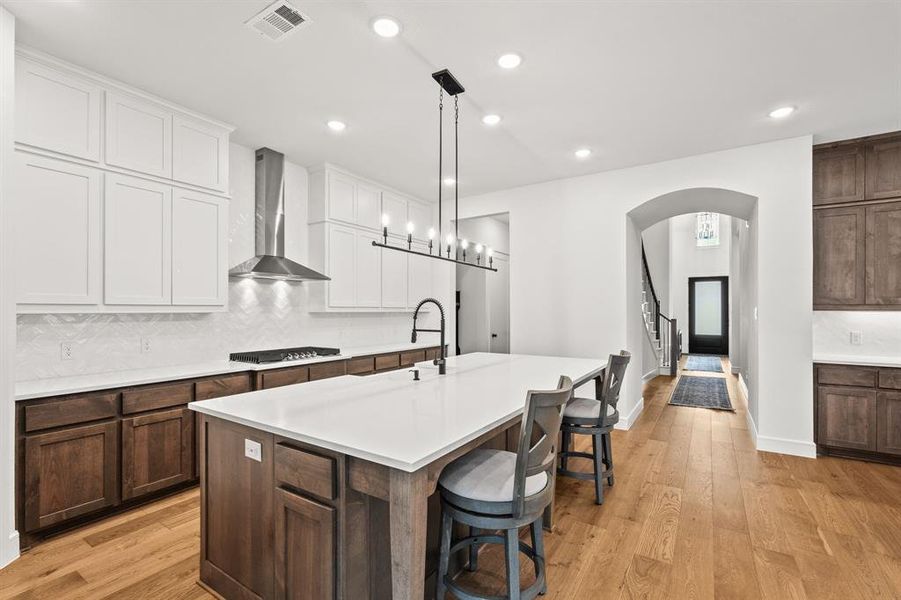 Kitchen with tasteful backsplash, light wood finished floors, and recessed lighting
