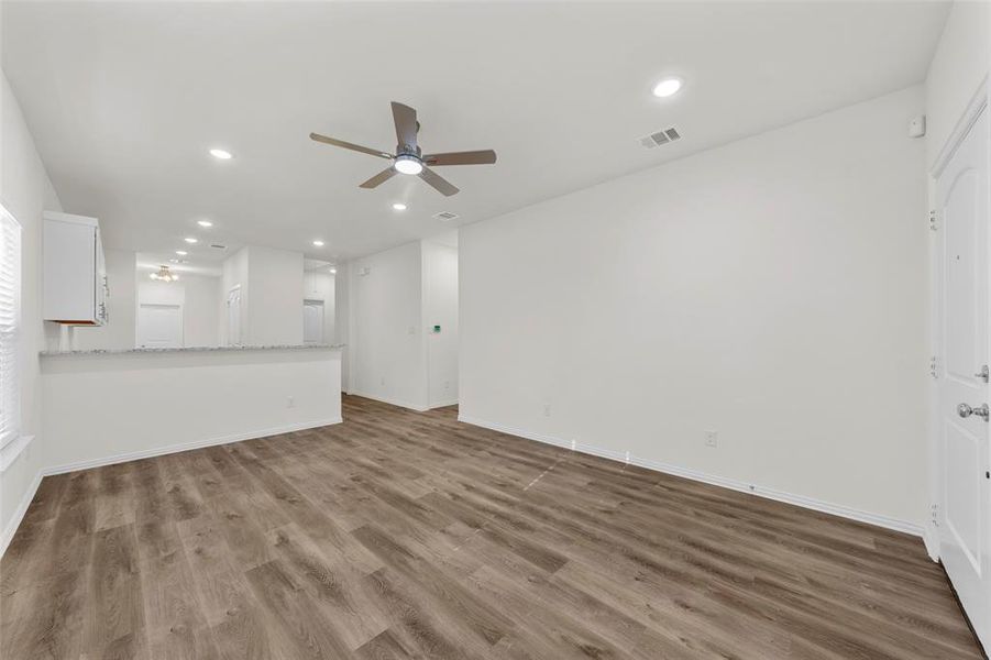 Unfurnished living room featuring ceiling fan and hardwood / wood-style flooring