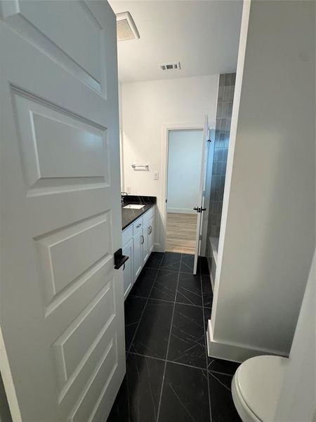 Full bathroom featuring visible vents, toilet, marble finish floor, and vanity