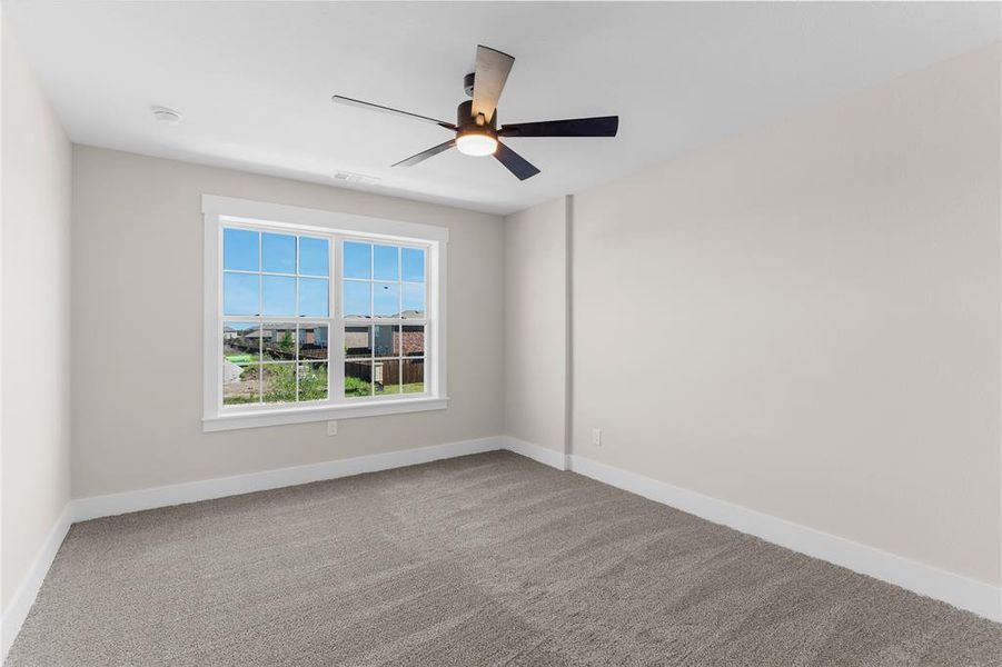 Spacious room featuring neutral paint, gray carpet, a contemporary ceiling fan, and a large window with white trim