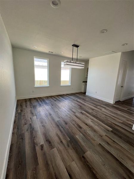 Unfurnished dining area featuring dark wood-style flooring and recessed lighting