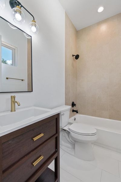 A well-appointed bathroom with a modern vanity, sleek mirror, and tiled shower.
