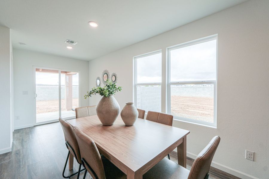 A dining room table with a vase of flowers on it. A dining room table with a vase of flowers on it.