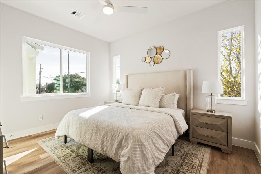 The primary bedroom is light-filled and quietly expansive, framed by custom windows and anchored by two dedicated closets for effortless everyday living.