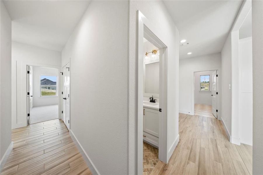 Hall with light wood-type flooring and recessed lighting