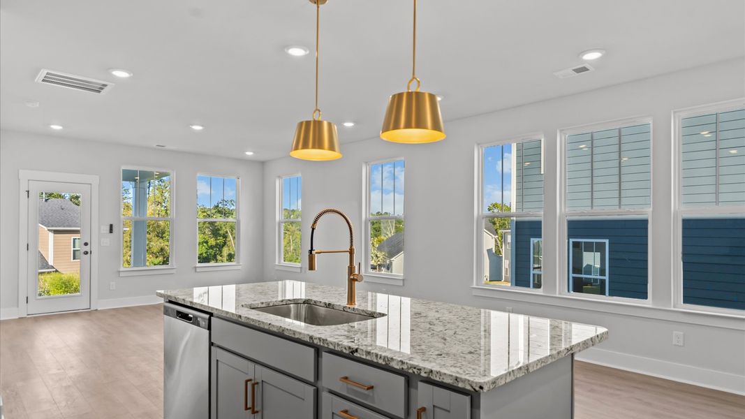 Highly skilled kitchen design includes a 7-foot island, quartz countertops, and stylish pendant fixtures